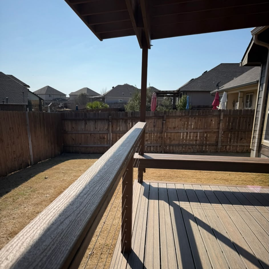 Close-up of deck railing and composite decking beneath the patio cover.