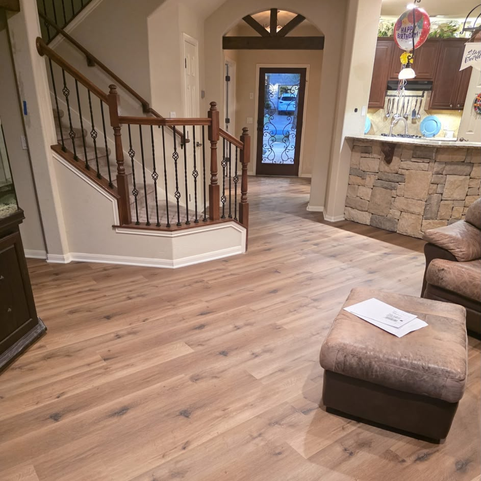 New luxury vinyl plank flooring beside the staircase and front entry of the home.